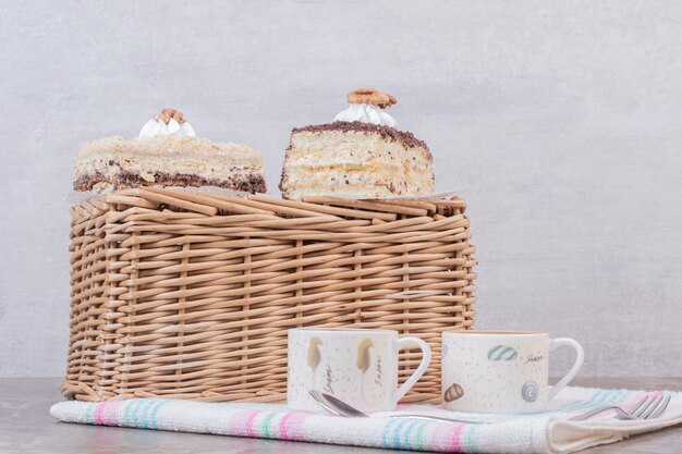 Homemade cakes and cups of coffees on tablecloth.