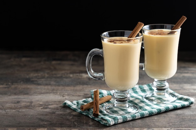 Free photo homemade eggnog with cinnamon on wooden table typical christmas dessert close up