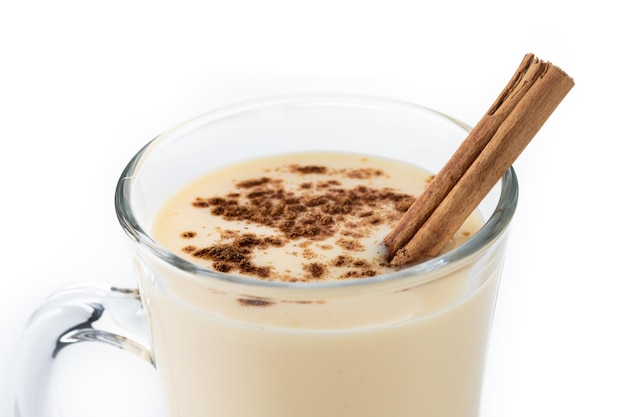 Free photo homemade eggnog with cinnamon on wooden table. typical christmas dessert isolated on white background