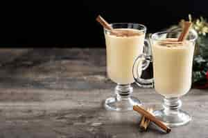 Free photo homemade eggnog with cinnamon on wooden table typical christmas dessert