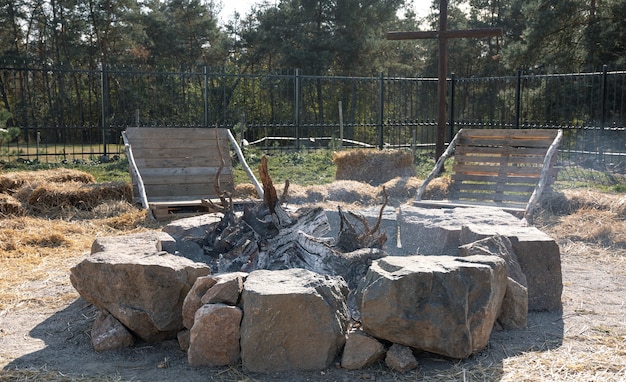 Free Photo a homemade fire fenced with stones and two benches nearby