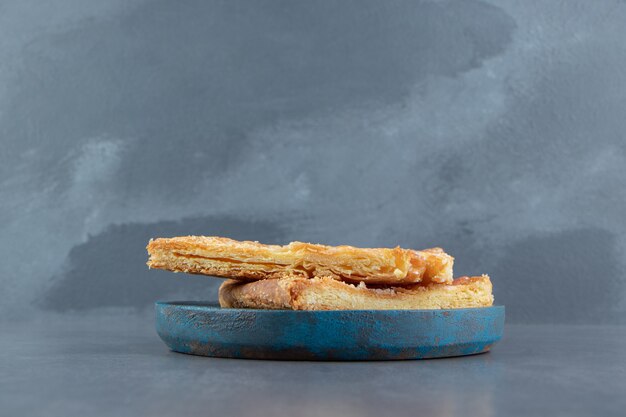 Homemade fresh triangle pastries on blue plate.