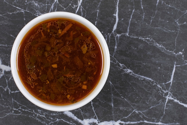 Homemade hot soup in white bowl.