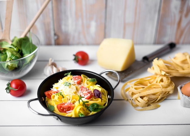 Free photo homemade italian spaghetti pasta garnish with cheeses; basil leaves and slice of tomato