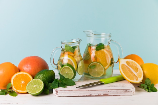 Free photo homemade lemonade jugs with light blue background