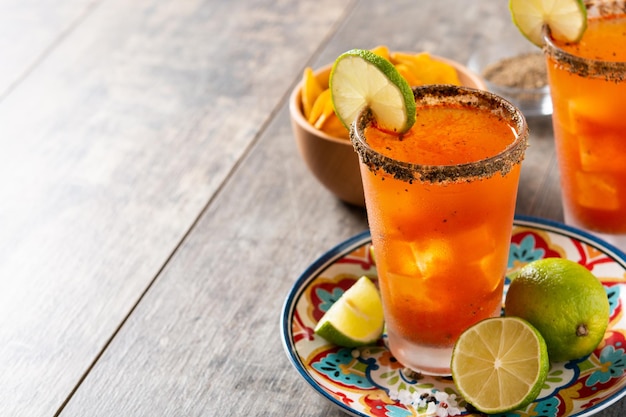 Homemade michelada cocktail with beer lime juicehot saucesalted rim and tomato juice