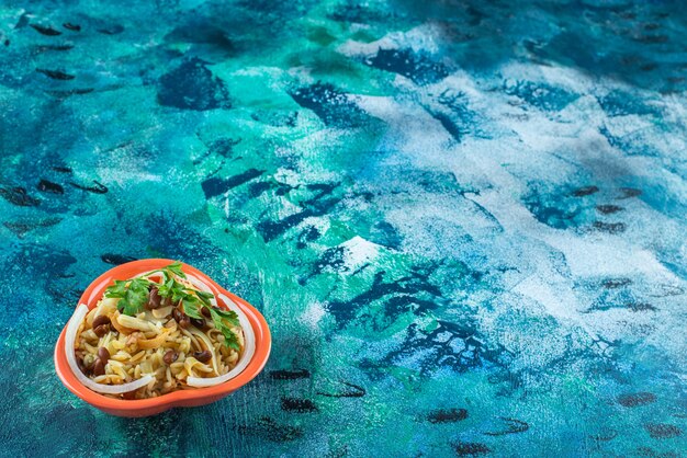 Homemade noodle with beans on a bowl , on the blue table. 