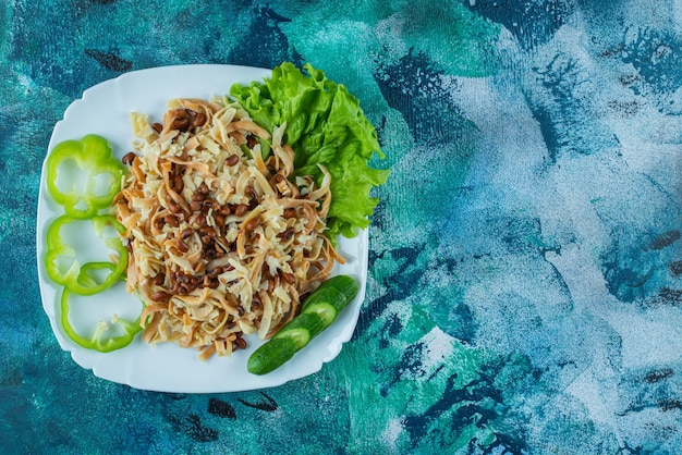 Free photo homemade noodle with slice pepper on a plate , on the blue background.