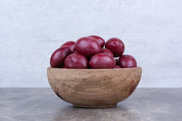 Homemade pickled fruits in wooden bowl.