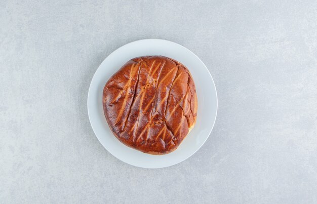 Homemade round pastry on white plate. 