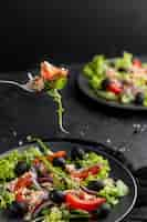 Free photo homemade salad with dark tableware