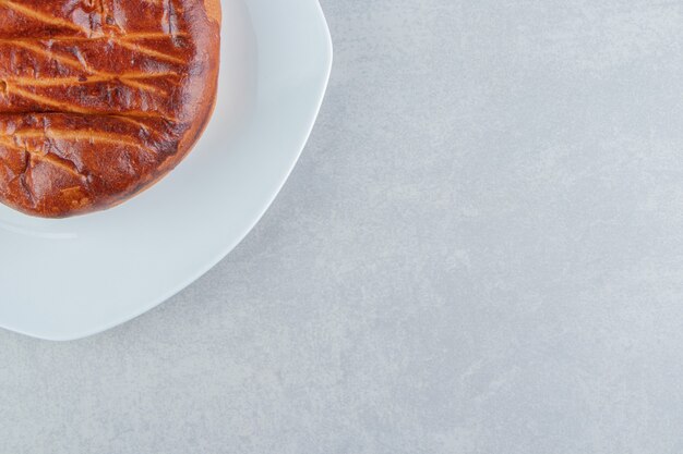 Homemade sweet bun on white plate. 