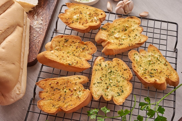 Free photo homemade tasty bread with garlic, cheese and herbs on kitchen table.