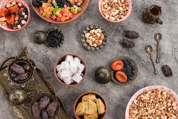 Free photo homemade turkish delight sweets with dried fruits and nuts with spoons on concrete backdrop