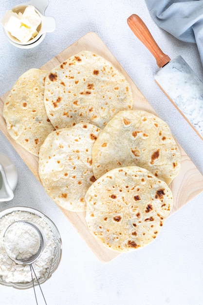 Free photo homemade wheat tortillas pita bread tortilla pita with ingredients for cooking on a white table top view vertical