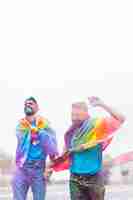 Free photo homosexual couple in colorful powder having fun on parade