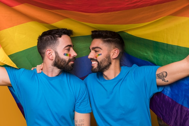 Homosexual couple of men embracing on rainbow flag