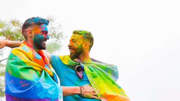 Free photo homosexual couple with painted faces laughing and embracing