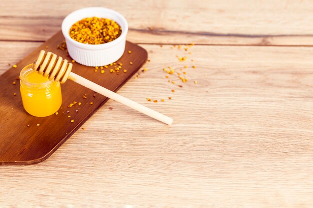 Honey and bee pollen on wooden textured