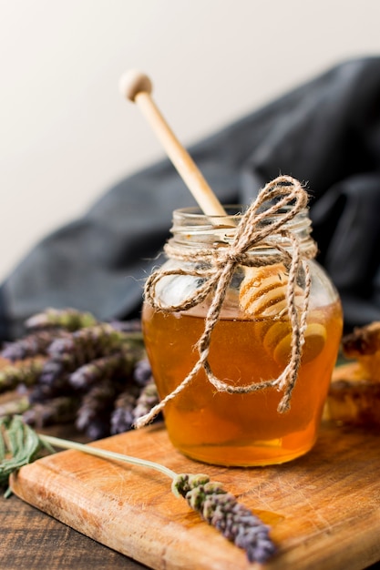 Free photo honey jar with spoon and lavender