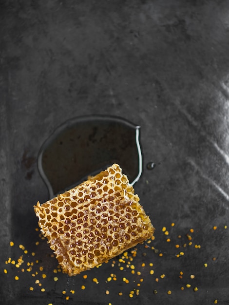 Honeycomb piece with bee pollens on kitchen counter