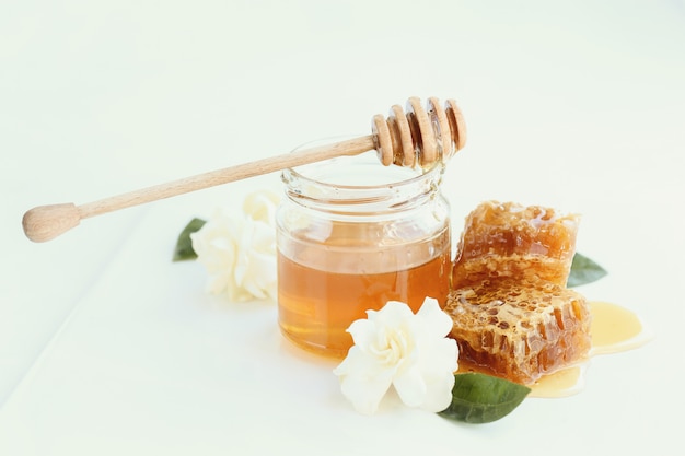 Free photo honeycomb with jar and flowers