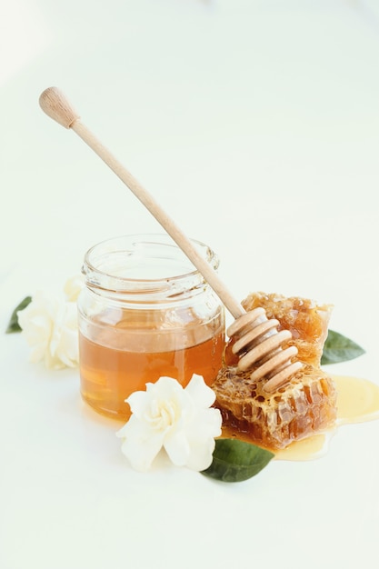 Free photo honeycomb with jar and flowers