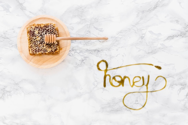 Free Photo honeycomb with text written with honey on white marble backdrop