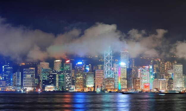 Hong Kong skyline at night with clouds over Victoria Harbour.