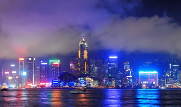 Hong Kong skyline at night with clouds over Victoria Harbour.