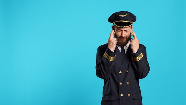 Free Photo hopeful airplane pilot posing with fingers crossed to fulfill wish, preparing for commercial flight work. cabin captain praying for luck and fortune, acting wishful and having beliefs.