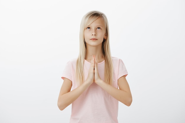 Hopeful blonde little girl praying god, pleading