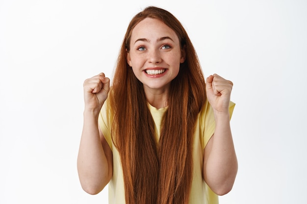 hopeful girl looking up at screen with clenched fists and excited smiling face place bet on white.