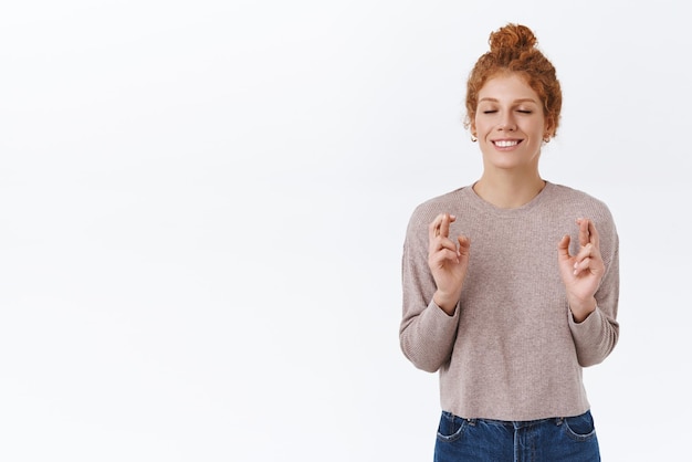 Free Photo hopeful gorgeous redhead woman with curly hair in bun close eyes and smiling happy have dream cross fingers good luck hope something happen believe dreams come true make wish