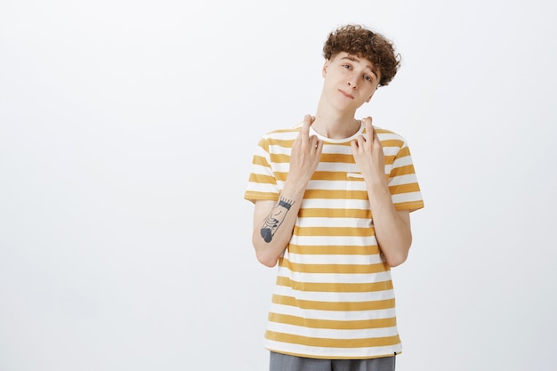 Free photo hopeful teenage guy posing against the white wall