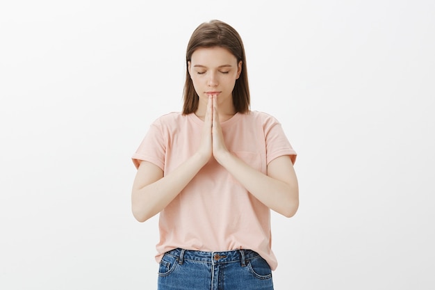 Free photo hopeful woman praying, woman clasp hands together and pleading, supplicating