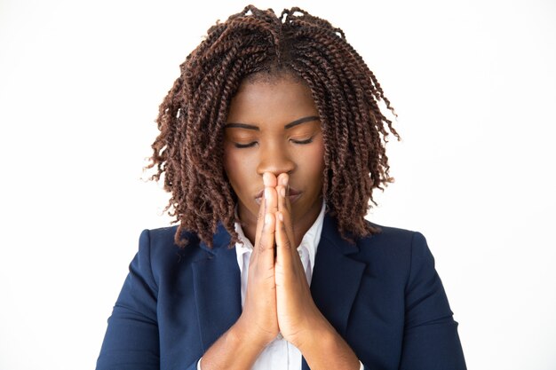 Hopeful young businesswoman praying