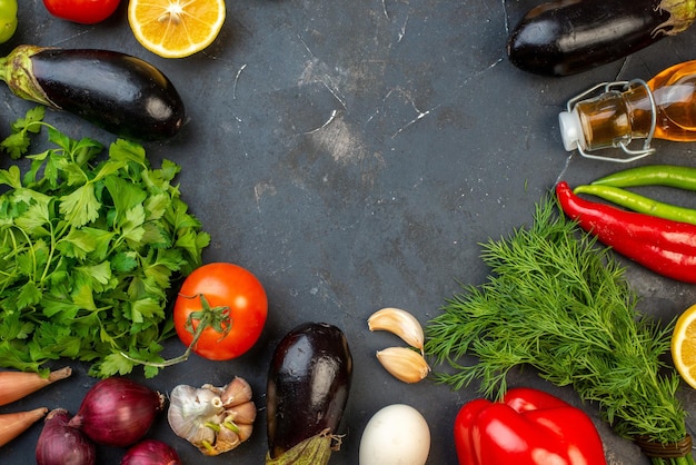 Horiontal view of round shaped free space fresh vegetables fallen oil bottle eggs lemons spices on black background