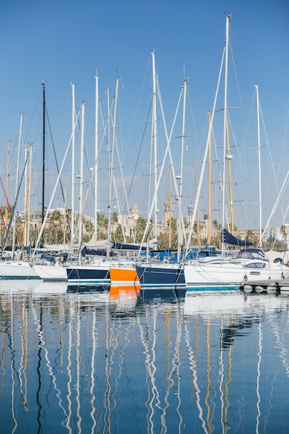 Free Photo horizontal photo of luxury and glamorous yachts and sailboats docked or parked in marina port in barcelona, spain