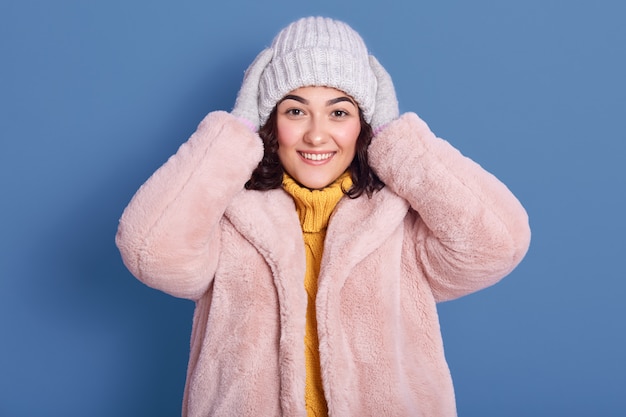 Free photo horizontal shot of beautiful cheerful female wearing faux fur coat