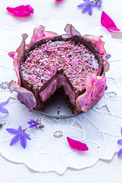 Free Photo horizontal shot of a cut pear raw vegan purple cake with dehydrated pears on a white tabletop