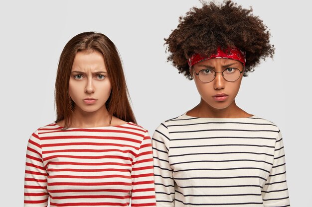 Free Photo horizontal shot of displeased female with negative expressions, dressed in striped clothes, have sullen looks