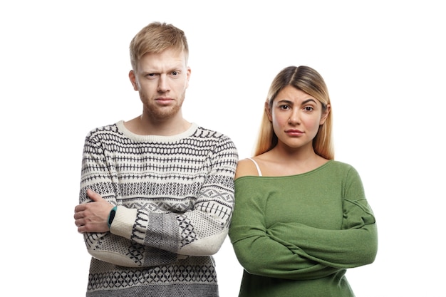 Free Photo horizontal shot of distrustful young couple crossing arms and staring, having doubtful skeptical looks. human facial expressions, emotions, feelings, attitude and body language