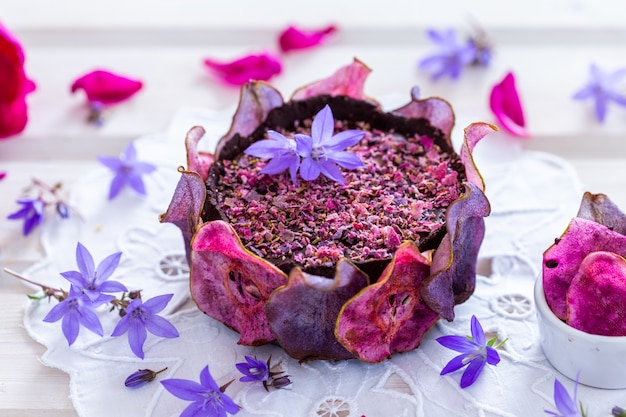 Free photo horizontal shot of a pear raw vegan purple cake with dehydrated pears on a white tabletop - vegan