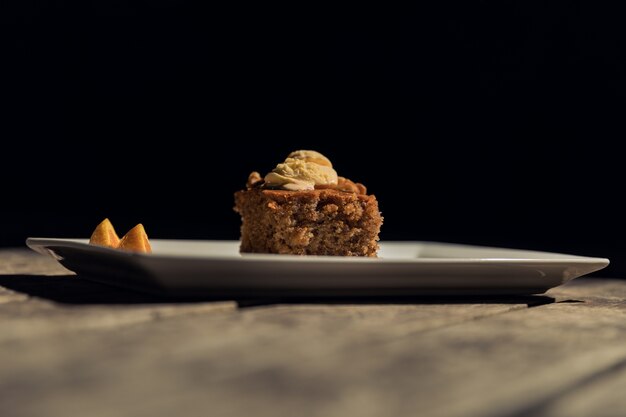 Horizontal shot of a piece of cake on a white plate on a wooden surface