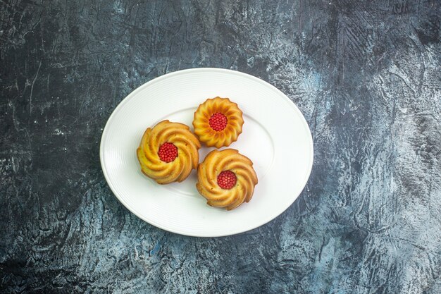 Horizontal view of delicious biscuits on a white plate on dark surface