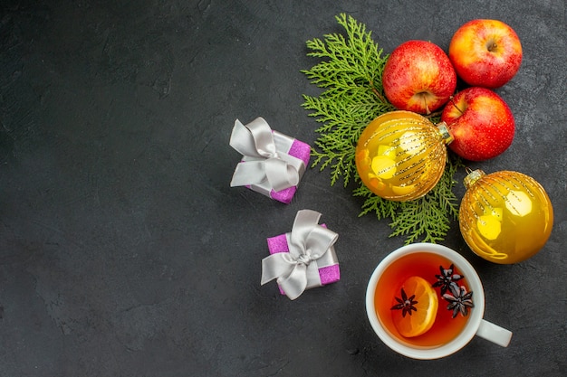 Free Photo horizontal view of gifts and natural organic fresh apples and decoration accessories a cup of tea on black background