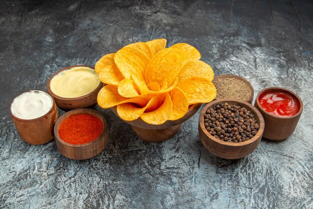 Horizontal view of homemade potato chips decorated like flower shaped on gray table