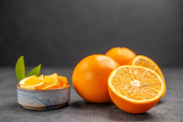 Horizontal view of whole and chopped fresh lemons on dark table