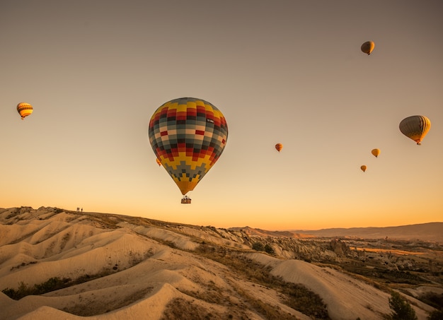 Free photo hot air balloons over the hills and the fields during sunset in cappadocia, turkey